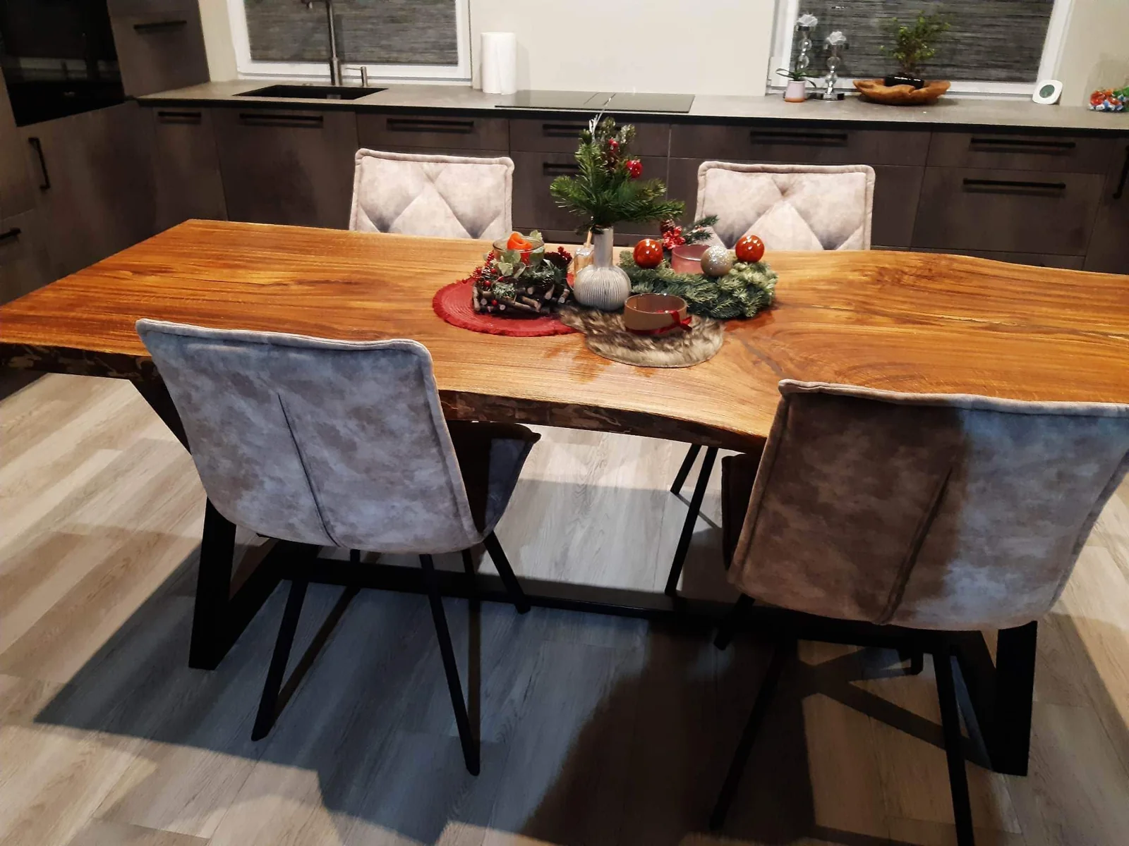 Natural-edge dining table with rich golden grain and a black geometric metal base — Photograph 2