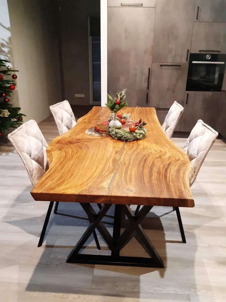 Natural-edge dining table with rich golden grain and a black geometric metal base
