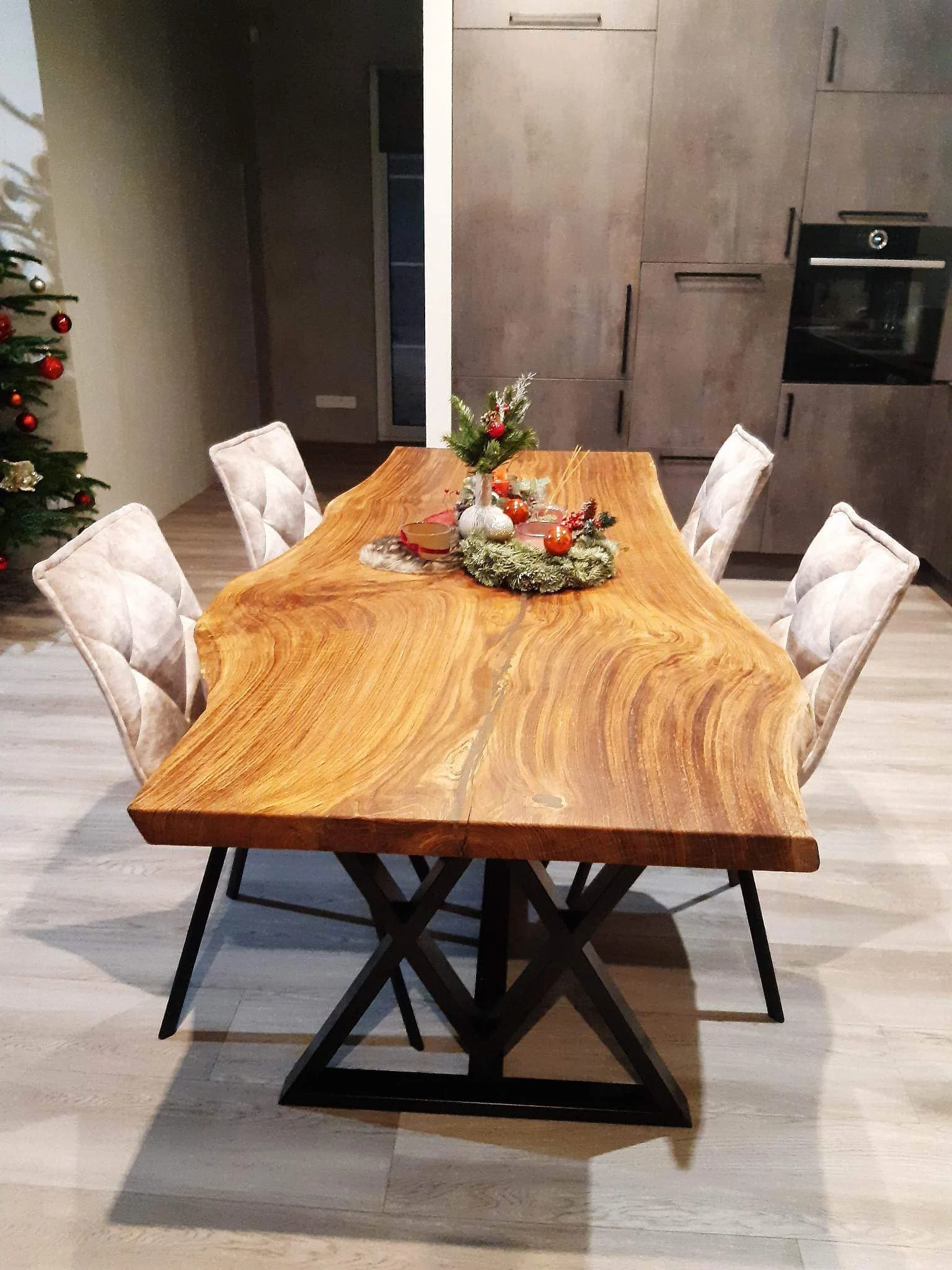 Natural-edge dining table with rich golden grain and a black geometric metal base