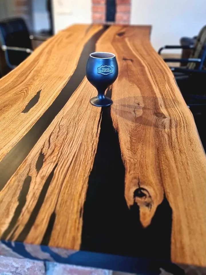 Close view of a wooden table with black resin running between warm-grained sections