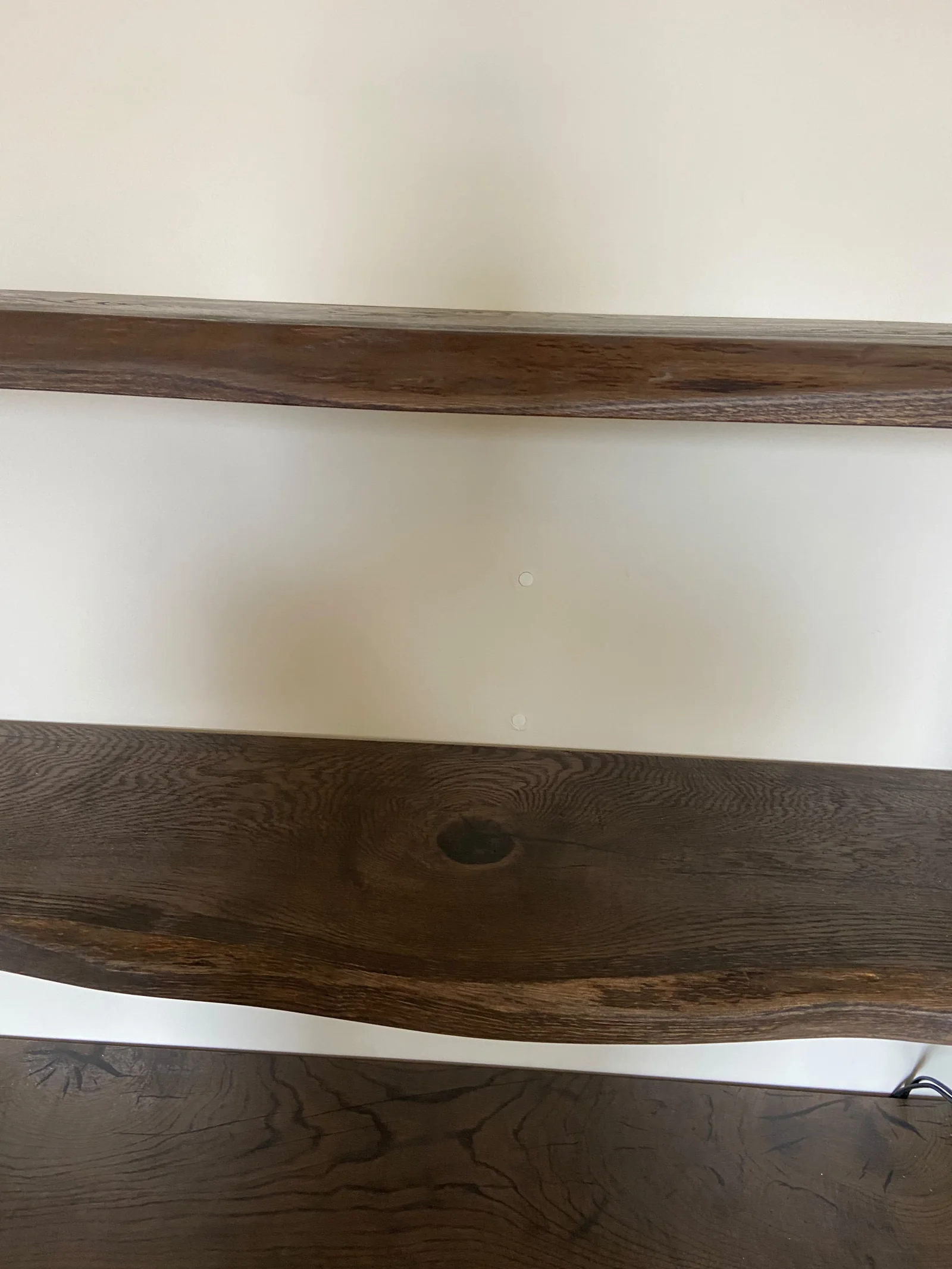 Dark natural-edge wooden floating shelves fitted into a white alcove — Photograph 2