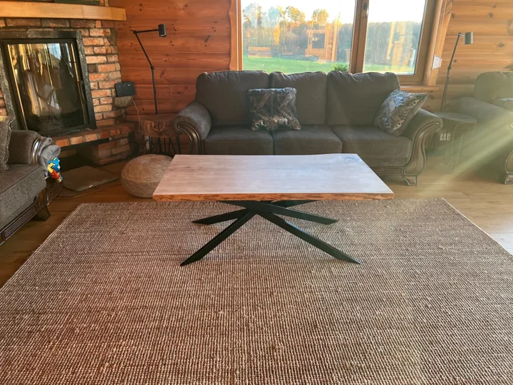 Rectangular natural-edge coffee table with an angular black metal base