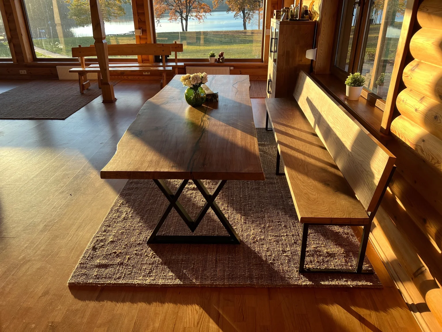 Natural-edge wooden dining table and matching bench in a sunlit room — Photograph 2