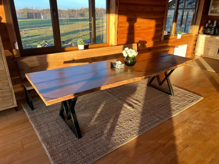 Natural-edge wooden dining table and matching bench in a sunlit room