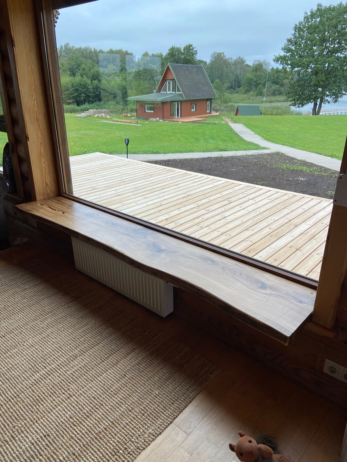 Broad natural-edge wooden windowsill in a timber interior — Photograph 2